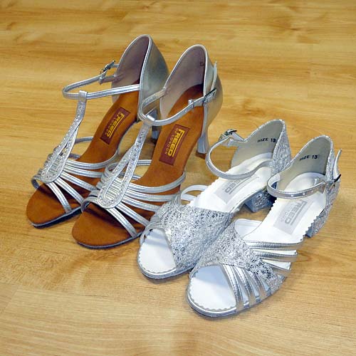 A childrens size ballroom and latin shoe compared with an adults sized shoe.